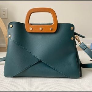 Teal handbag with brown wooden handles.